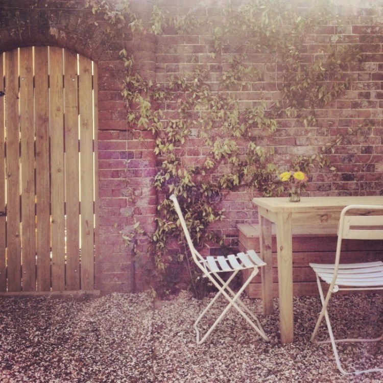 garden-gate-and-table-in-shingle-walled-garden